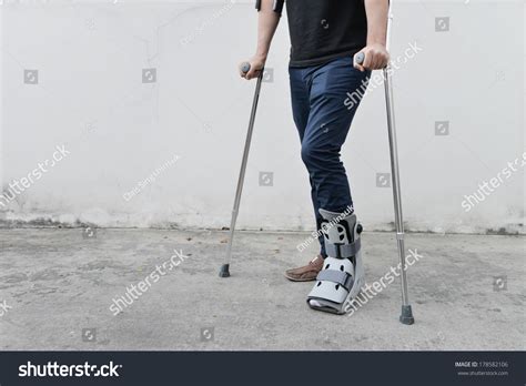 Sprained ankles can be really painful. Man With Broken Ankle Wearing Ankle Support With Walking ...