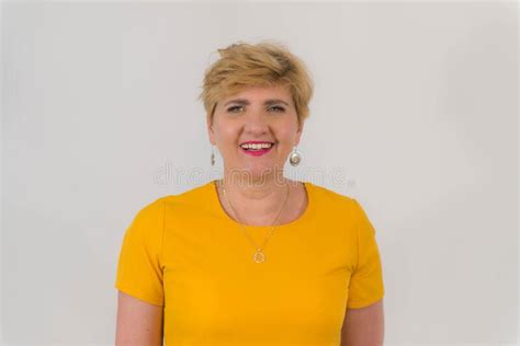 Elegant Pretty Middle Aged Woman In A Yellow Dress Stock Photo