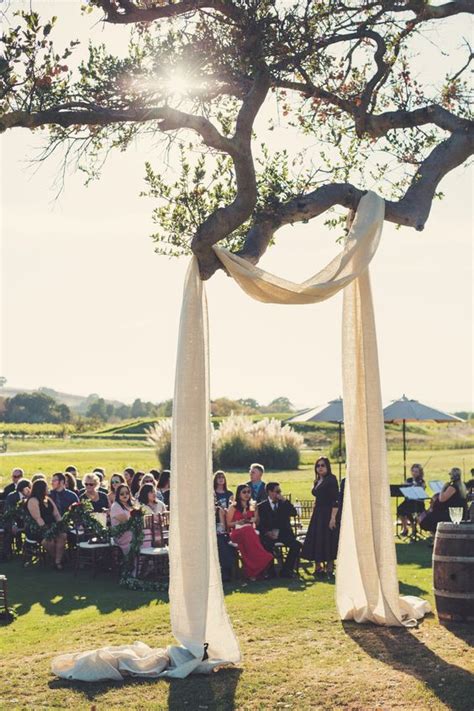 Some Light Fabric Hung On A Tree Branch As A Wedding Arch Is A Creative