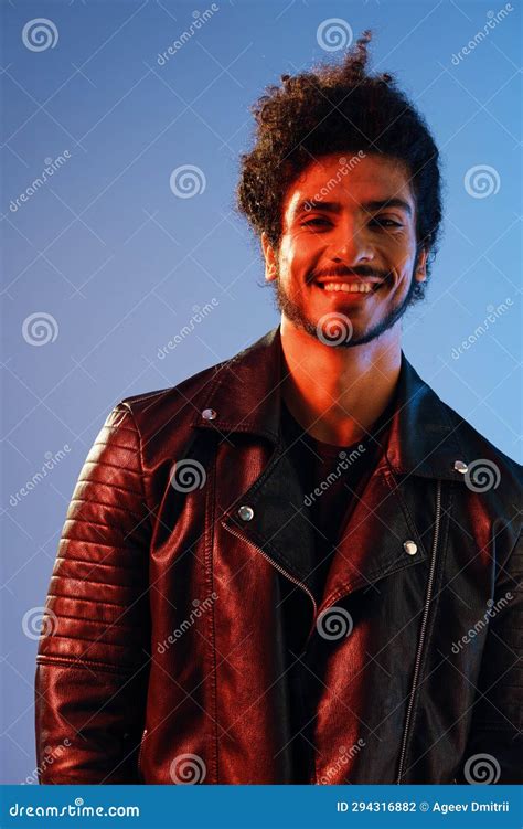 Portrait Of A Stylish Man With Curly Hair On A Blue Background