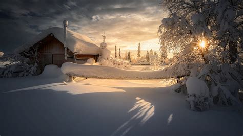 Snow Covered House And Trees During Sunrise Under Cloudy