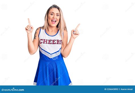 Young Beautiful Blonde Woman Wearing Cheerleader Uniform Smiling Amazed And Surprised And
