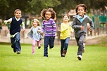 42308258 - group of young children running towards camera in park - G.R ...