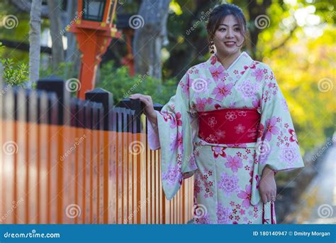 beautiful japanese geisha girl posing in floral silk kimono in traditional environment in kyoto