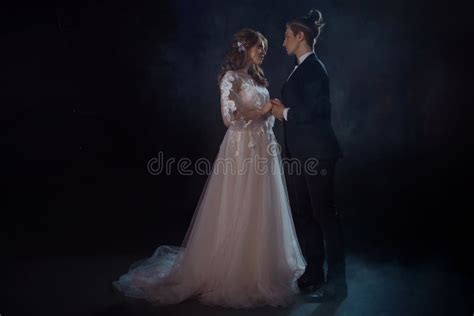 romantic mysterious portrait of bride and groom low key guy and girl look at each other with