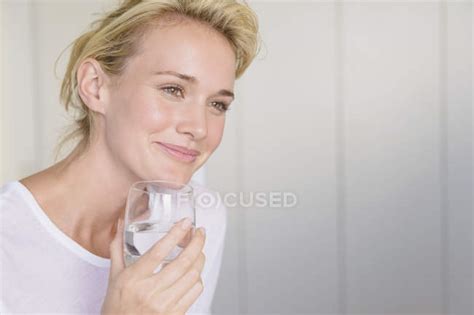 Smiling Woman Holding Glass Of Water — Clothes Room Stock Photo