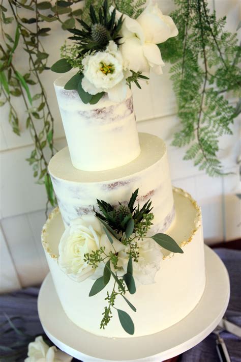 semi iced and textured buttercream wedding cake with fresh flowers and gold leaf pretty wedding