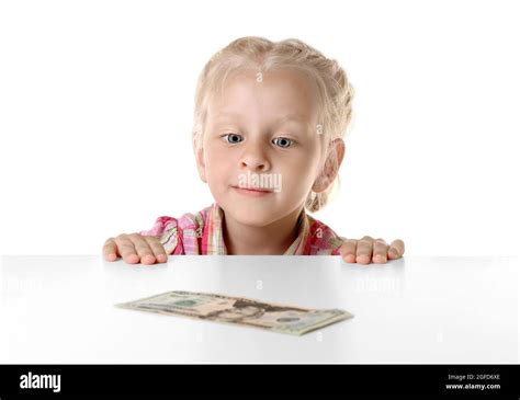 Funny Little Girl Hiding Behind White Table And Looking At Dollar Stock