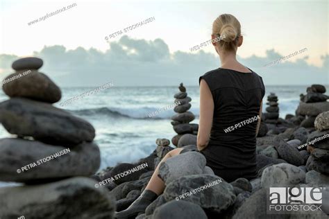 Spain Tenerife Costa Adeje Woman Sitting Between Cairns At The Coast