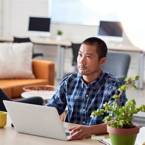 Young Asian Architect Deep In Thought Working In Office Stock Image