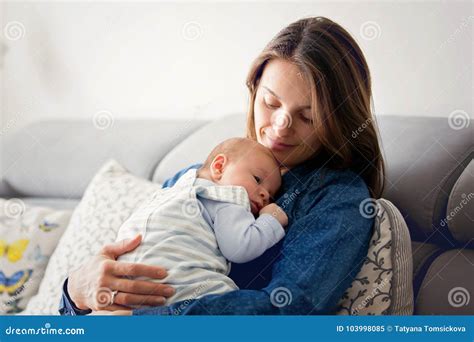 Young Mother Kissing Her Newborn Baby Boy At Home Stock Image Image