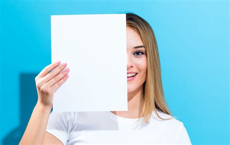 Woman Holding A Blank Sheet Of Paper In Front Of Her Face Royalty Free