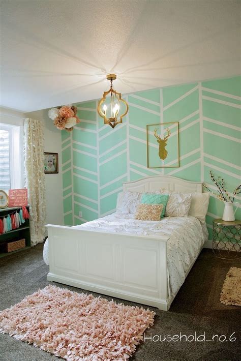 Brass sconces, fixed against a pink wallpapered accent wall, light white twin french headboards accenting beds dressed in pink and green bedding topped with white duvets and monogrammed shams. love the design on wall plus pink blue and gold combo ...