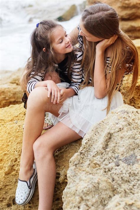 two little sister girls sitting on the beach stock image image of coast love 56345557