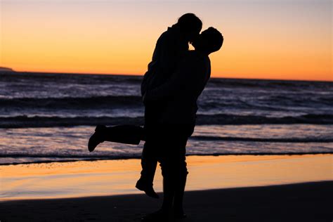 Wallpaper Id A Couple Kissing And Embracing By The Beach At Sunset One Lifting The