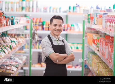 Asian Male Shopkeeper Standing In Front Of The Groceries Store Stock