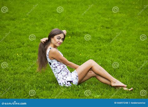 sexy frau im kurzen kleid das auf grünem gras sitzt stockfoto bild von person kaukasisch