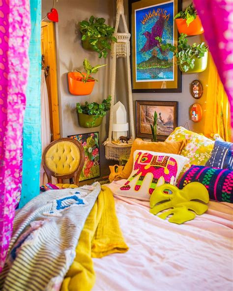 A Bed With Lots Of Colorful Pillows And Pictures On The Wall Above It