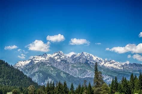 Green And White Snow Capped Mountain Under Blue Skies · Free Stock Photo