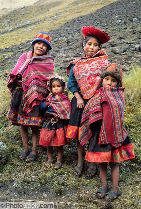 Four Andean Mountain Children Dress In Traditional Red Ponchos In The