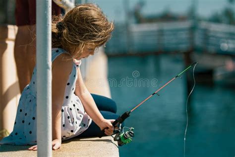Focused Serious Little Children Girl Catch A Fish By A Fishing Rod