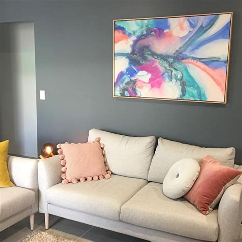 A Living Room With Two Couches And A Painting On The Wall