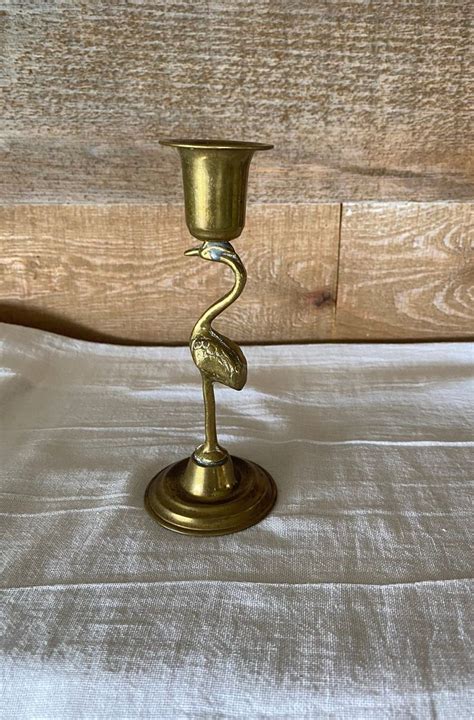 A Small Brass Candle Holder On A Bed
