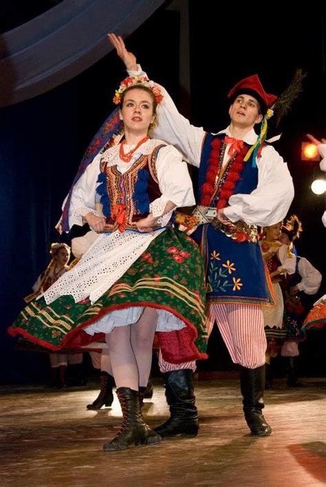 two people dressed in folk costumes on stage