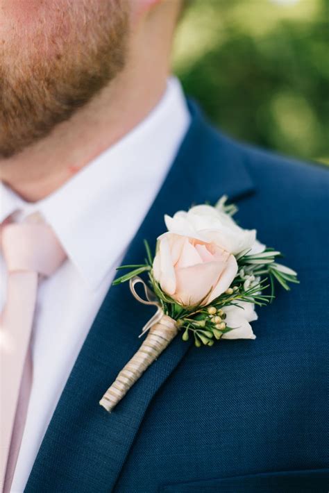 A Man In A Suit And Tie With A Boutonniere On His Lapel