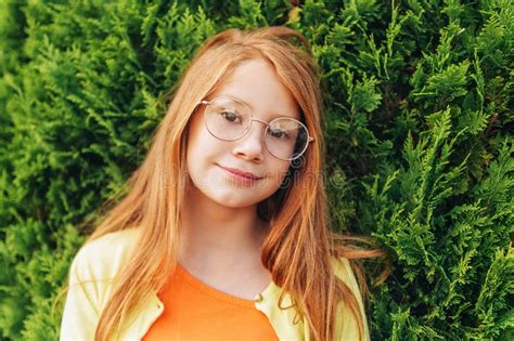 Portrait Of Adorable Red Haired Girl Wearing Glasses Stock Photo