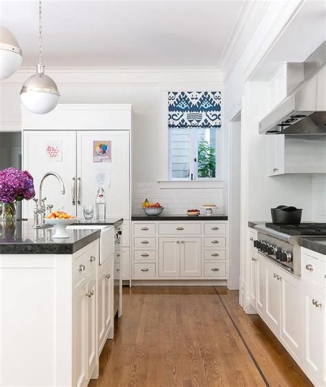 I had a dark black polished granite for years and we switched it out for white marble a few years ago — it is so much easier to keep clean looking. White shaker style kitchen with black granite countertops ...