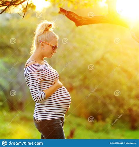 pregnant woman on second trimester posing in sunny garden in the backlit stock image image of