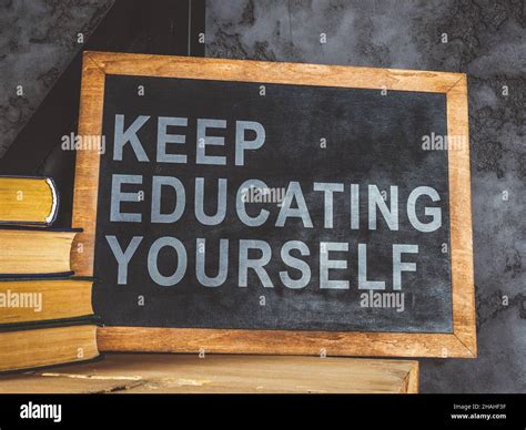 Blackboard Near Wall With Words Keep Educating Yourself Stock Photo Alamy