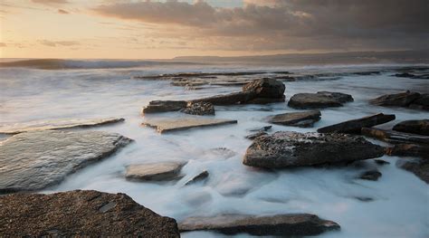 Rocky Seashore Seascape With Wavy Ocean During Sunset Photograph By