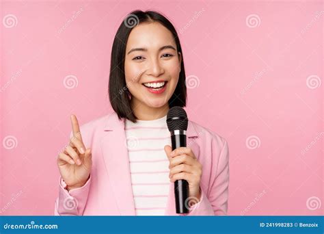image of enthusiastic asian businesswoman giving speech talking with microphone holding mic