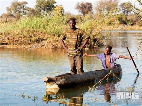 Kavango Man And Boy In Their Fishing Boat On The Okavango River Stock