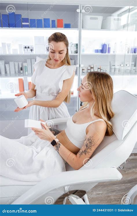 Young Woman Discussing Skincare Products With Cosmetologist Stock Image