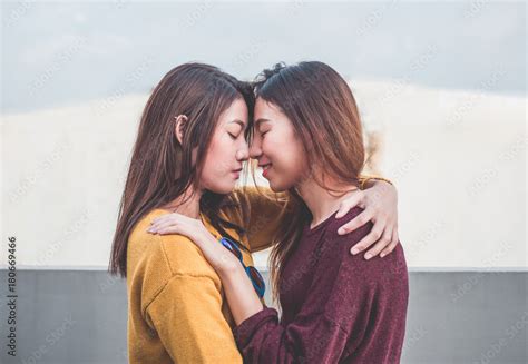 asia lesbian lgbt couple hug and nose kiss on rooftop of building with happiness moment 스톡 사진