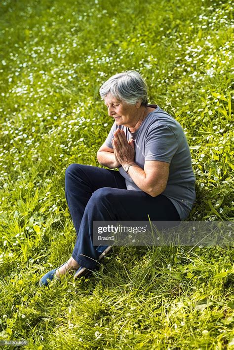 Old Woman Doing Yoga Meditation Exercises In Grass High Res Stock Photo