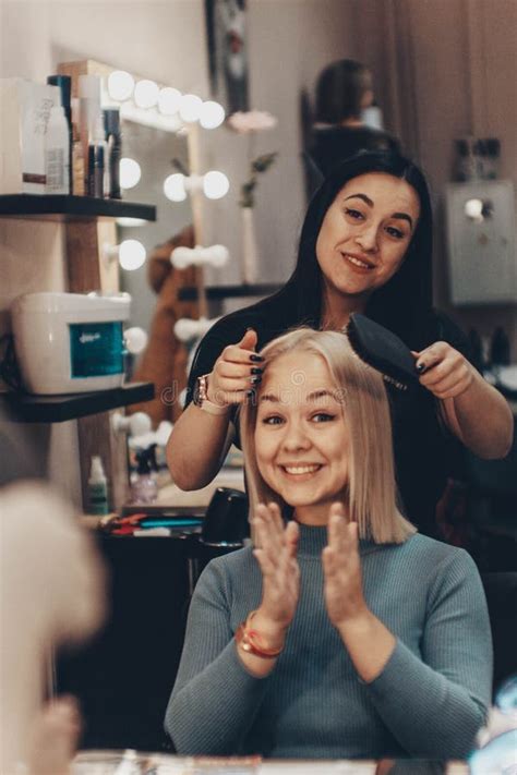 Beautiful Young Woman Hairdresser Giving New Haircut To Female Client