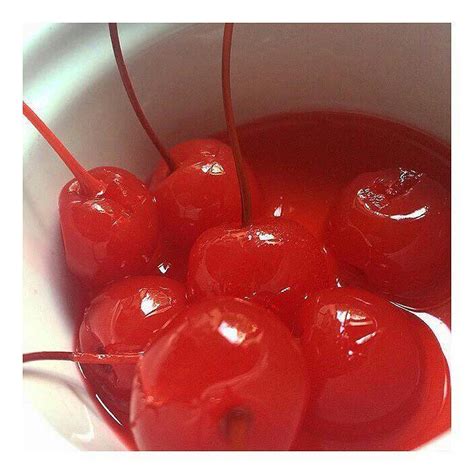 A White Bowl Filled With Cherries Sitting On Top Of A Table