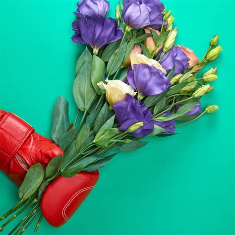 Premium Photo Hand In A Red Boxing Glove Holding A Bouquet Of Flowers