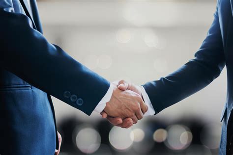 Portrait Of Two Businessmen Shaking Hands To Celebrate Partnership