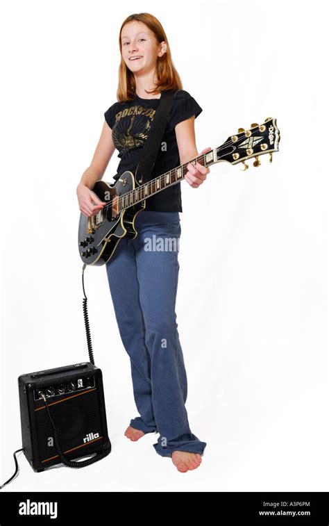 Smiling Teenage Girl Playing Electric Guitar With Amplifier On White