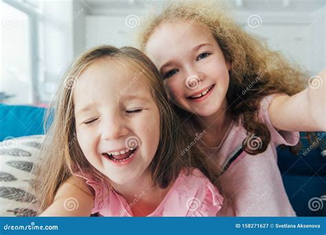 self portrait of crazy foolish sisters laughing together making selfie on mobile phone or