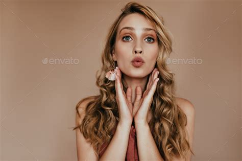 Carefree Blonde Woman With Nude Makeup Posing In Studio Indoor Shot Of Elegant Lady With Curly