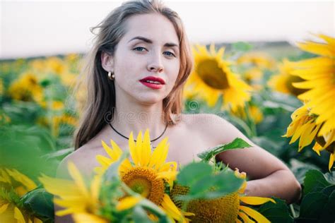 Young Slender Girl Without Clothes Is Covered With Sunflowers Stock