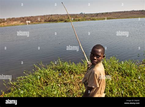 African Boy Fishing On The Lake Of Kubatsirana Farm Run By A Charity