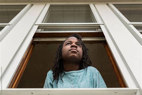 African American Girl On Her Porch Window By Stocksy Contributor