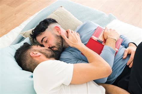 Romántico joven pareja homosexual acostado en la cama besándose Foto